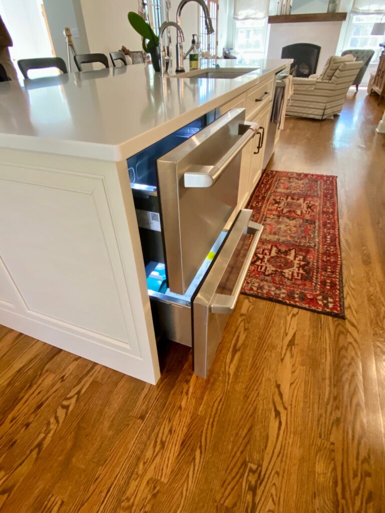 View of an exquisite kitchen island with a sink and mini fridge.